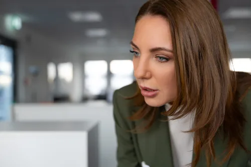 Videoproduzent bei der Erklärfilm-Produktion: Interviewpartnerin im Büro-Gespräch, konzentriert im Profil