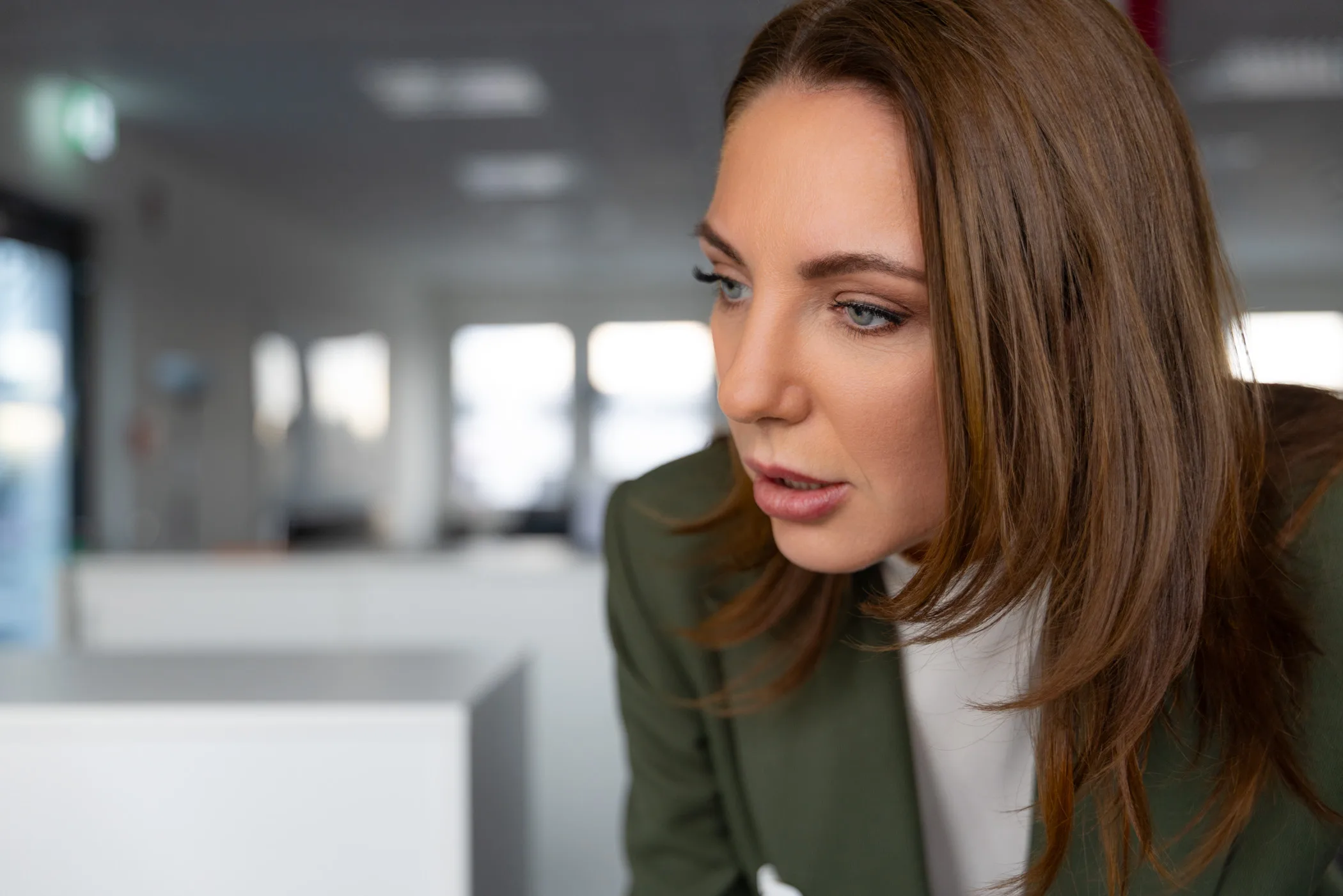 Videoproduzent bei der Erklärfilm-Produktion: Interviewpartnerin im Büro-Gespräch, konzentriert im Profil