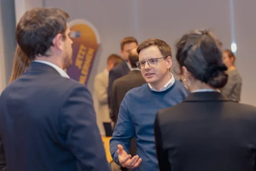 Eventfotograf Jahreshauptversammlung: Gruppengespräch am Rand des Saals