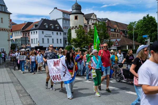 Eventfotograf beim CSD: bunte Schilder und Regenbogenfahnen im Demonstrationszug