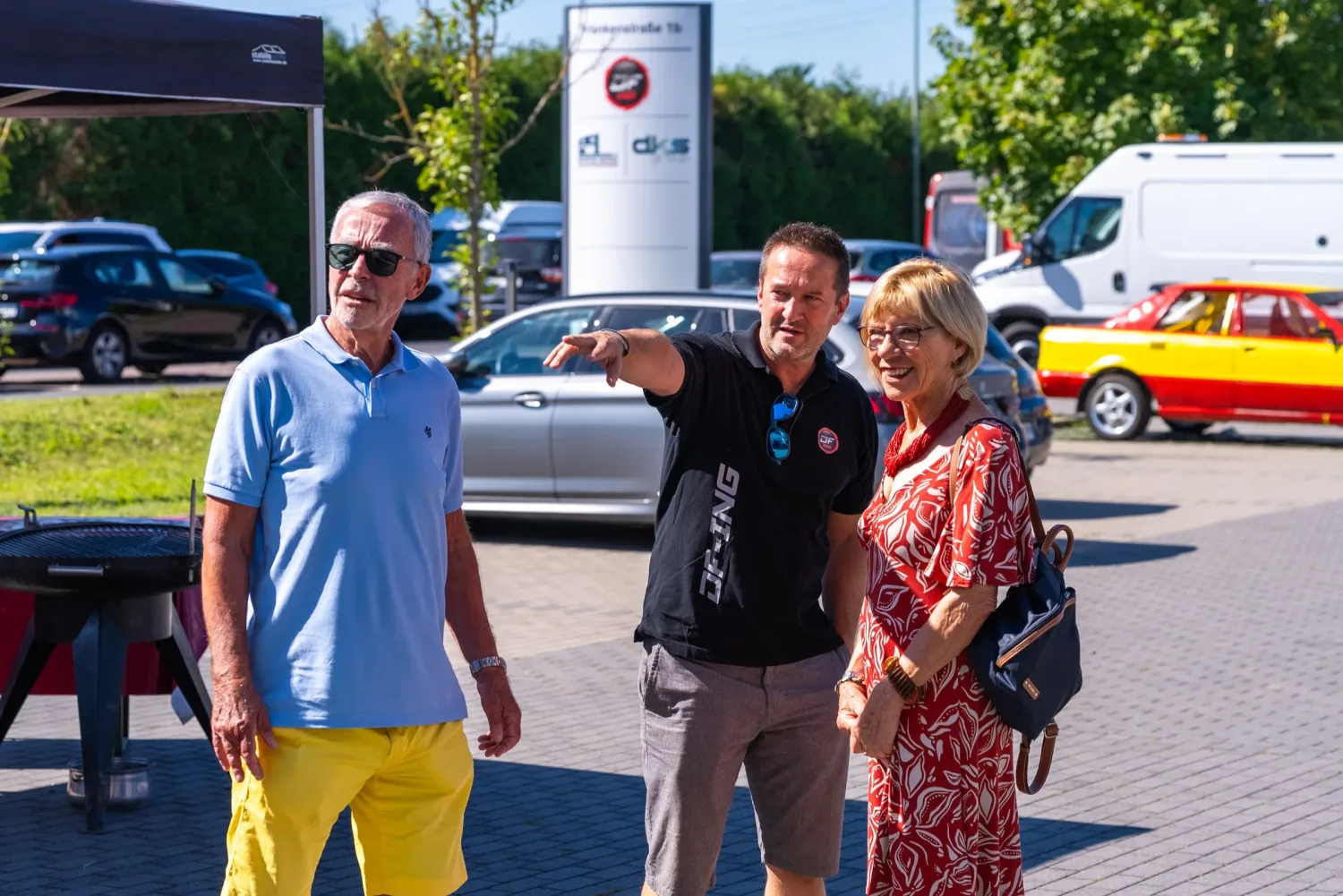 Eventfotograf beim Sommerfest: Gäste vor dem Firmenschild im Gespräch