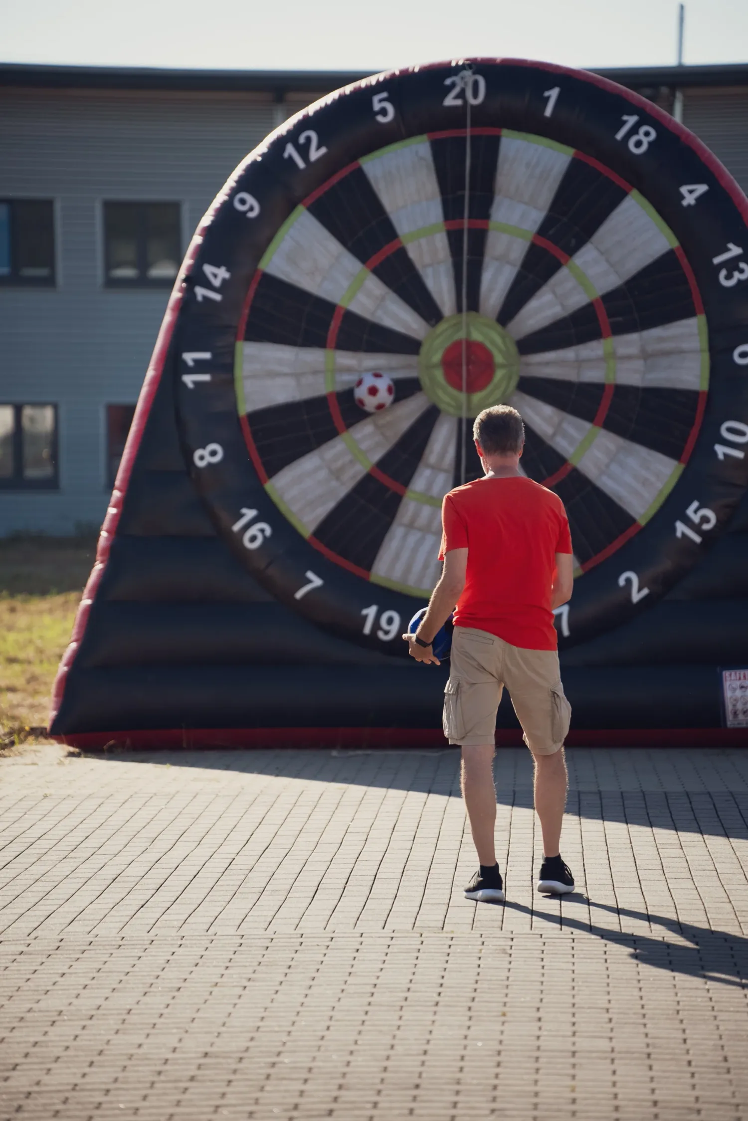 Eventfotografie Sommerfest: Gast beim Torwand-Dart auf der aufblasbaren Riesen-Dartscheibe