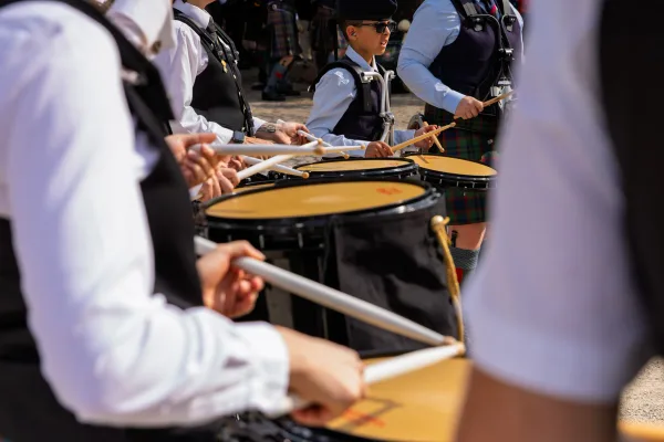 Eventfotograf beim Jubiläumsfest: Pipe Band aus Perth in traditioneller Tracht mit Dudelsack und Marschtrommel