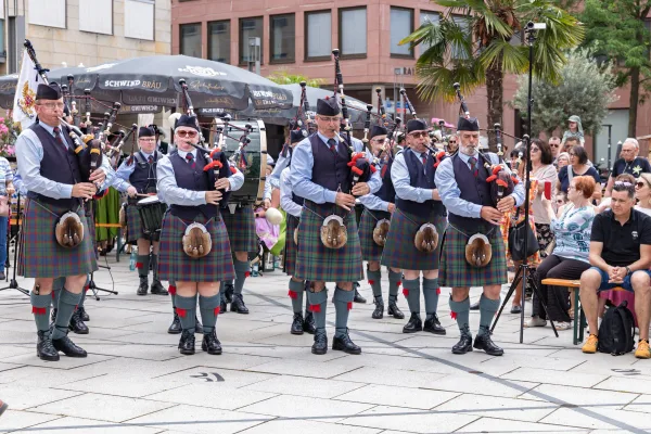 Eventfotograf beim Jubiläumsfest: Pipe Band aus Perth in traditioneller Tracht mit Dudelsack und Marschtrommel
