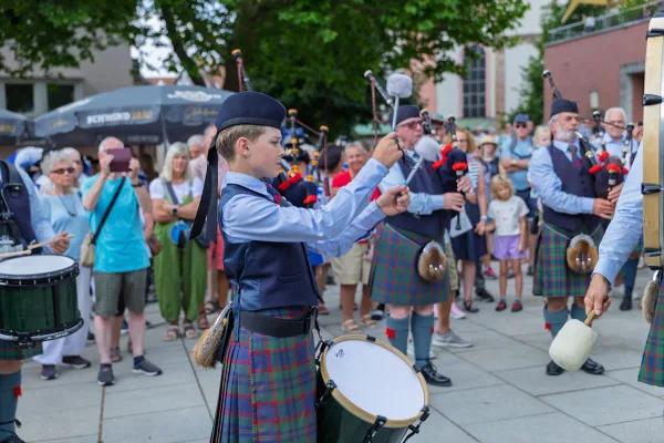 Eventfotograf beim Jubiläumsfest: Pipe Band aus Perth in traditioneller Tracht mit Dudelsack und Marschtrommel