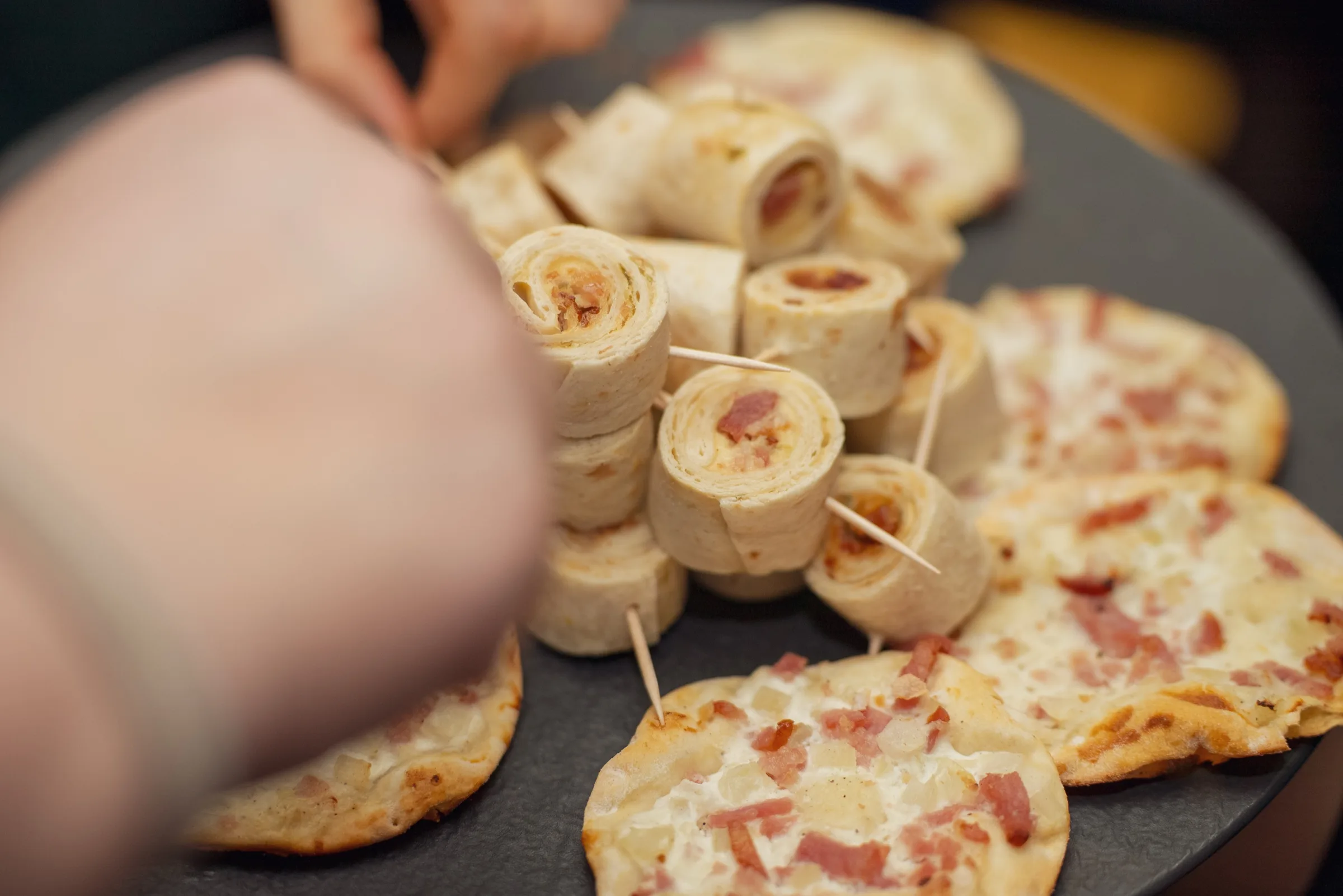 Eventfotografie Firmenfeier: Detailaufnahme der Fingerfood-Platte mit Wraps und Flammkuchen