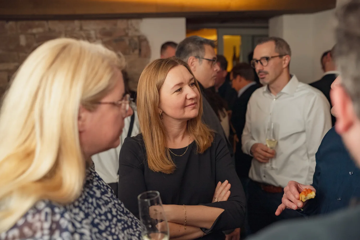 Eventfotograf beim Sektempfang der Weihnachtsfeier: Gäste im Stehen im Gespräch mit Fingerfood
