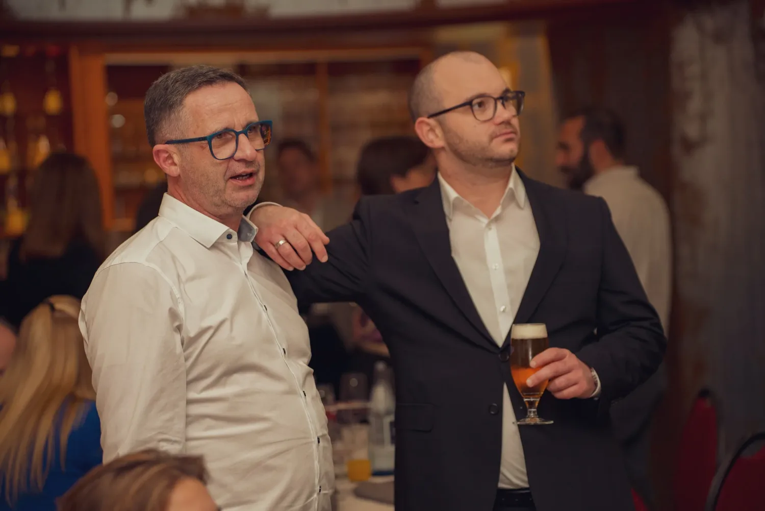 Eventfotografie Firmenfeier: zwei Gäste im Gespräch, einer mit Bierglas aus der Brennhaus-Brauerei