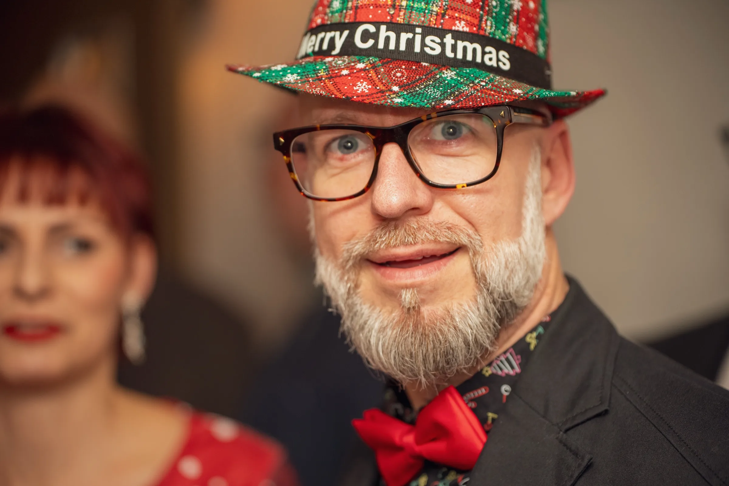 Eventfotografie Firmenfeier Aschaffenburg: Gast mit „Merry Christmas"-Hut blickt in die Kamera