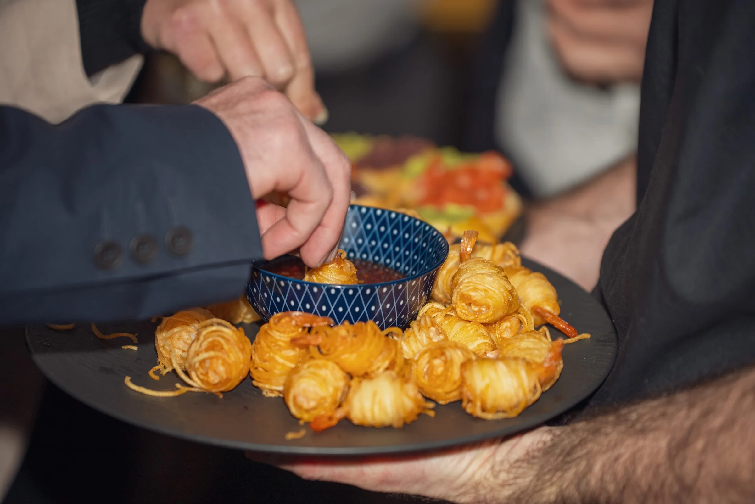 Eventfotograf Firmenfeier: Fingerfood-Platte mit knusprigen Garnelen-Röllchen beim Sektempfang