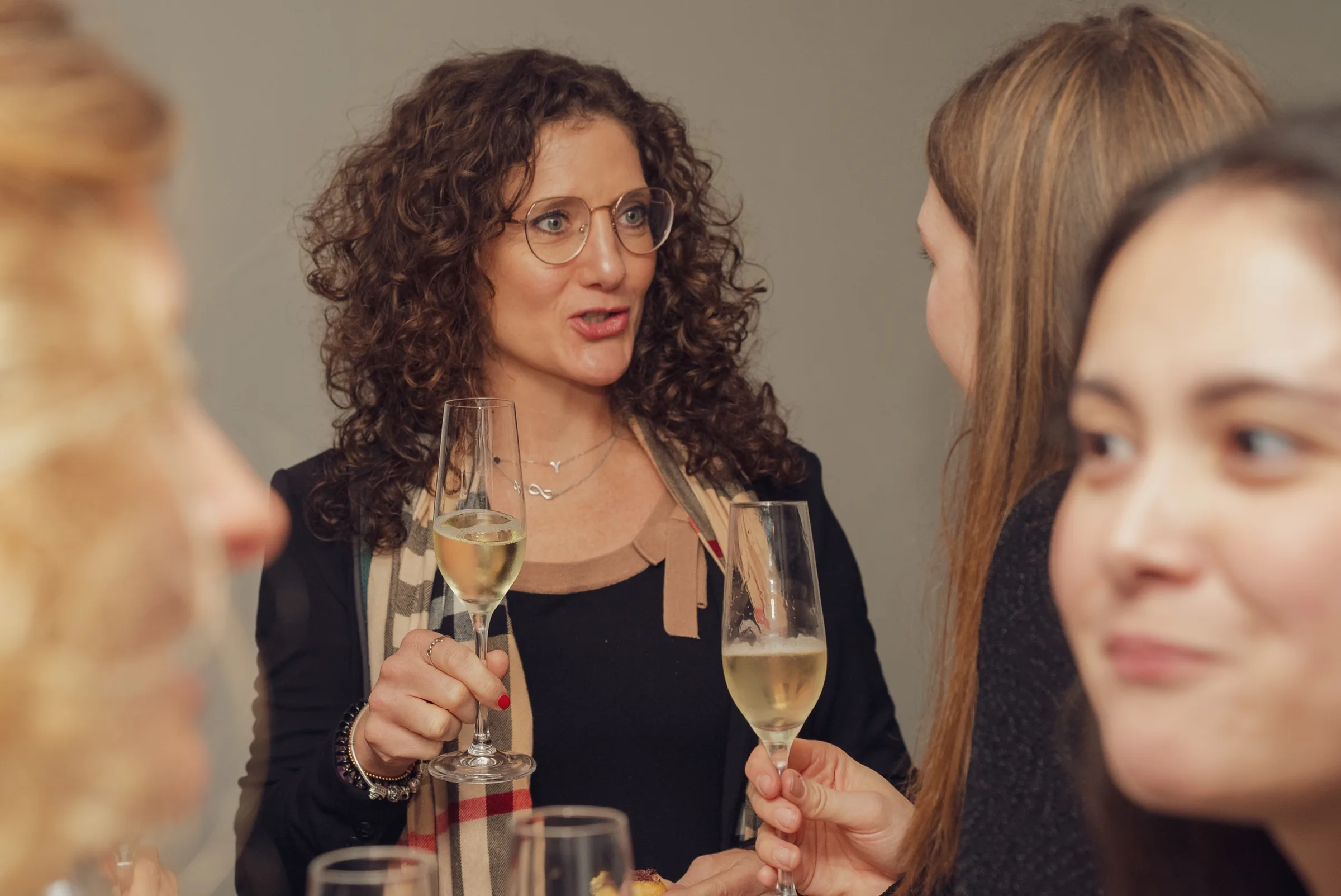 Eventfotograf Firmenfeier: Gästerunde mit Sektgläsern im angeregten Gespräch