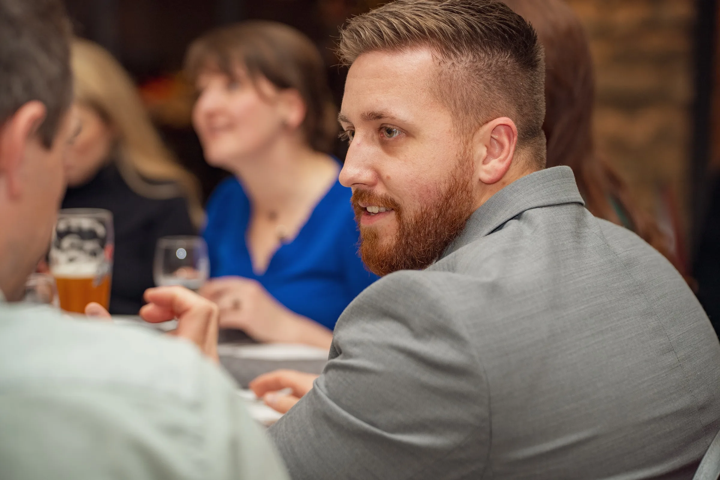 Eventfotografie bei der Firmenweihnachtsfeier: Gast im Profil aufmerksam im Gespräch
