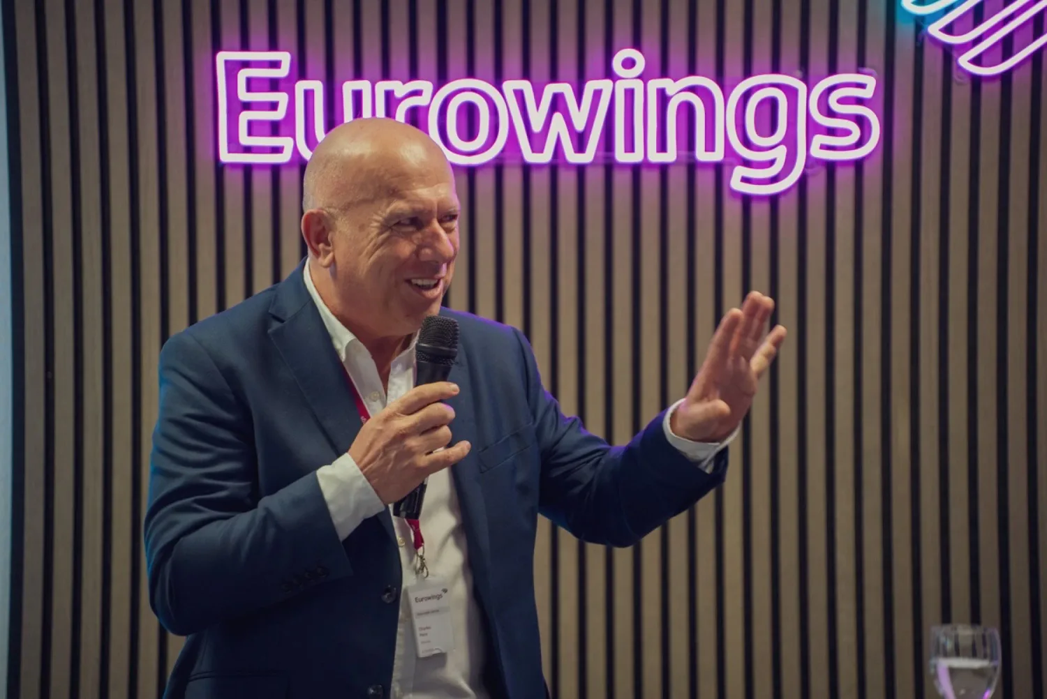 Videoproduktion für Eurowings: zweiter Redner mit Mikrofon vor dem Eurowings-Logo, im Gespräch mit den Gästen
