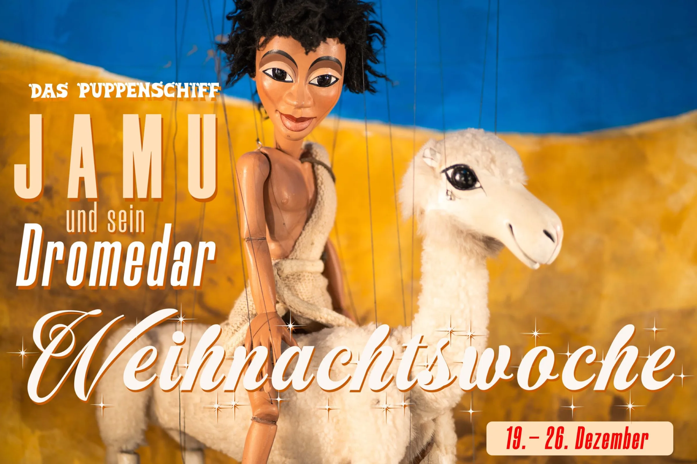 Social-Media-Kampagne Facebook-Cover 16:9: Marionette Jamu reitet auf dem Dromedar durch die Wüstenkulisse, Puppenschiff Weihnachtswoche