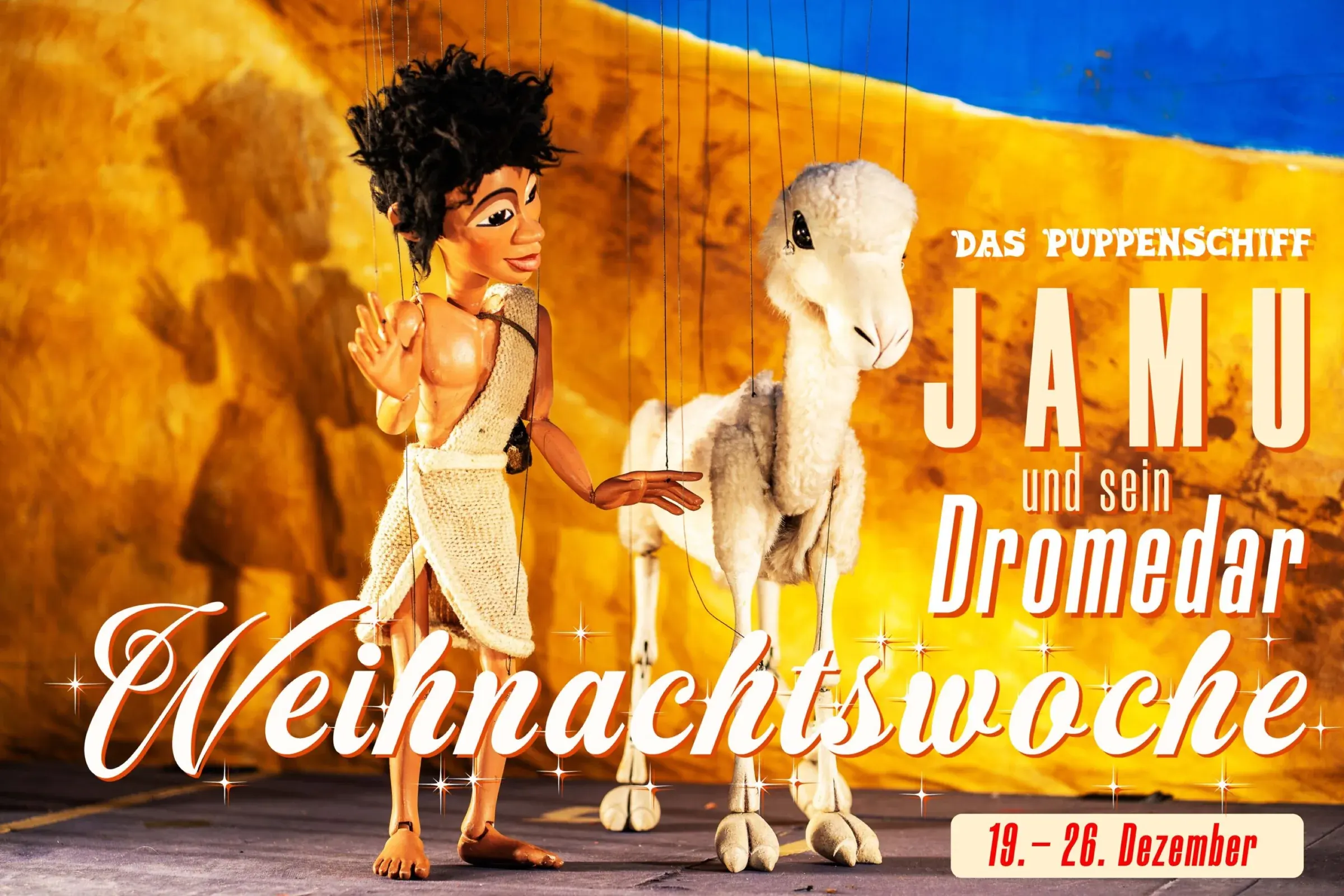 Social-Media-Kampagne Facebook-Cover 16:9: Marionette Jamu geht neben dem Dromedar vor Höhlenmalerei-Kulisse, Puppenschiff Weihnachtswoche