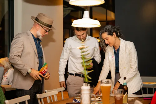 Eventfotografie Netzwerkabend: Gäste mit Namensschild beim Empfang der After Work Lounge