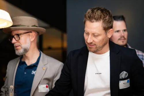 Eventfotografie Netzwerkabend: Gäste mit Namensschild beim Empfang der After Work Lounge