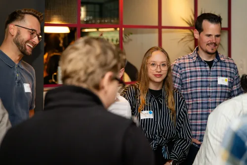 Eventfotografie Netzwerkabend: Gäste mit Namensschild beim Empfang der After Work Lounge
