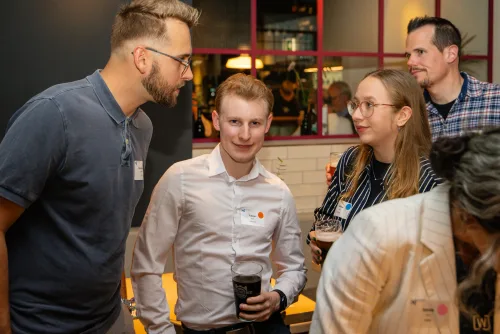 Eventfotografie Netzwerkabend: Gäste mit Namensschild beim Empfang der After Work Lounge