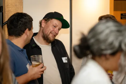 Eventfotografie Netzwerkabend: Gäste mit Namensschild beim Empfang der After Work Lounge