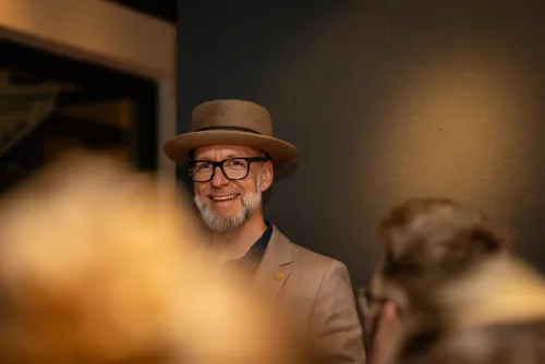 Eventfotografie Netzwerkabend: Gäste mit Namensschild beim Empfang der After Work Lounge